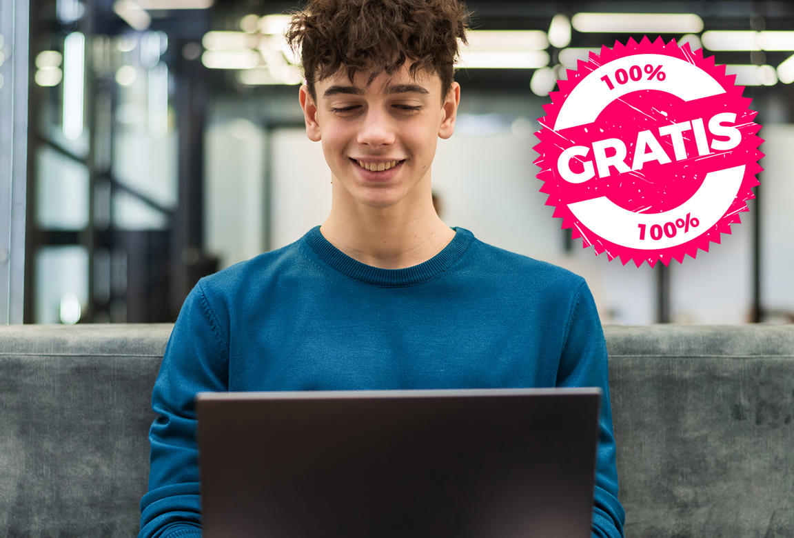 hombre-sonriente-joven-que-trabaja-con-una-computadora-portatil-en-una-oficina